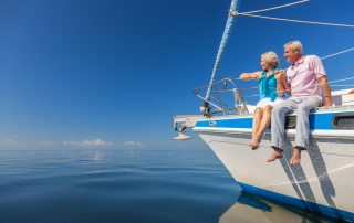 Personal pension vs SIPP- A happy senior couple sitting on a boat