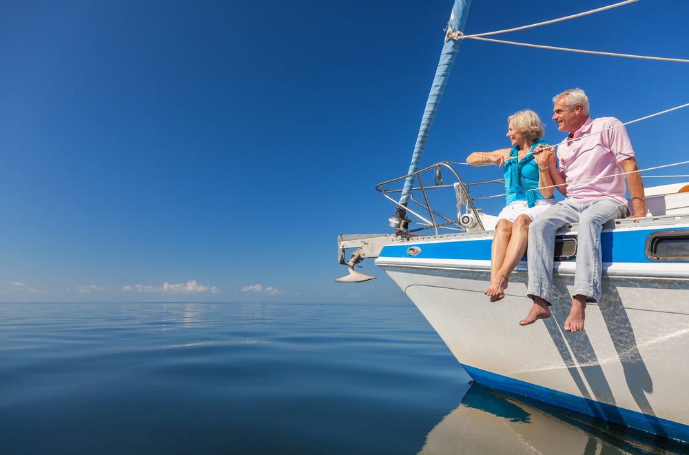Personal pension vs SIPP- A happy senior couple sitting on a boat
