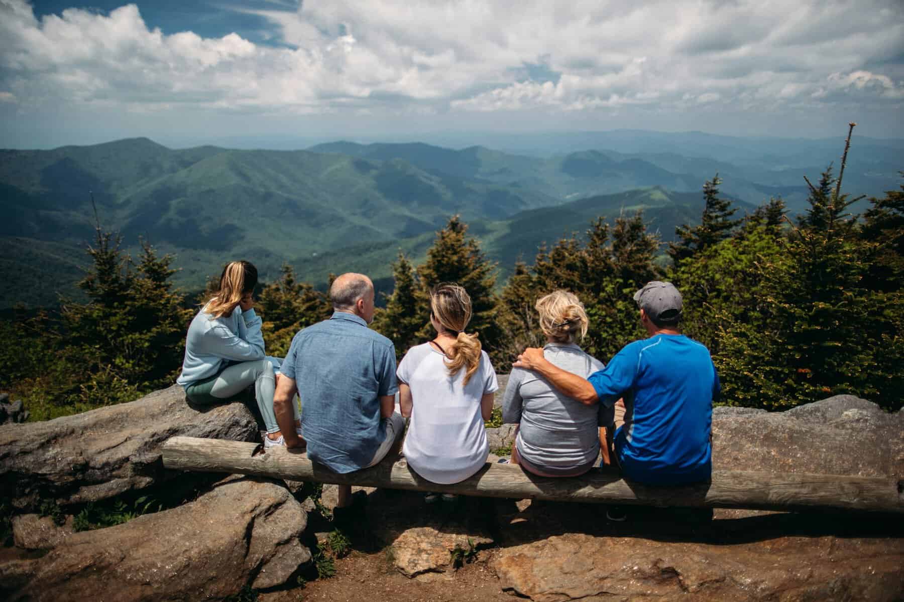 Intergenerational Wealth - Family sitting on a log overlooking forest